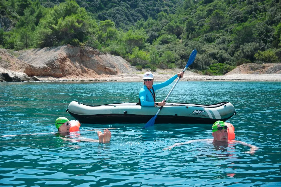 Guide in kayak with swimmers