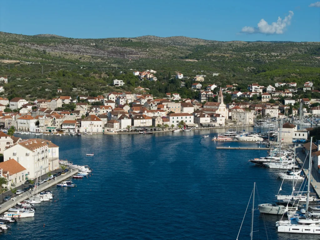 Boats and yachts moored in a charming Croatian marina town with historic white stone buildings