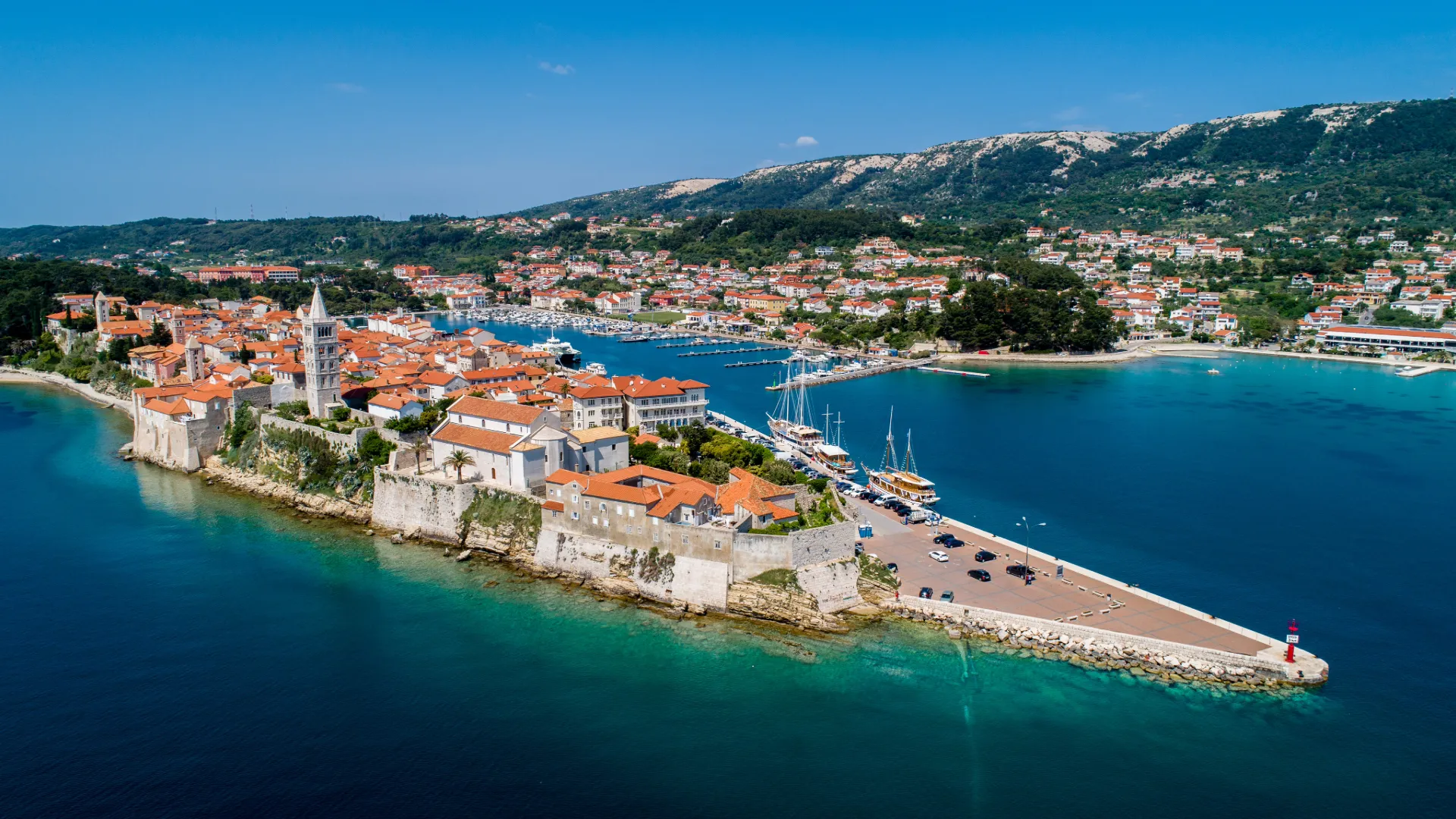 Rab old town and its four bell towers rising from the Adriatic, seen from the water on our Croatia yacht cruise